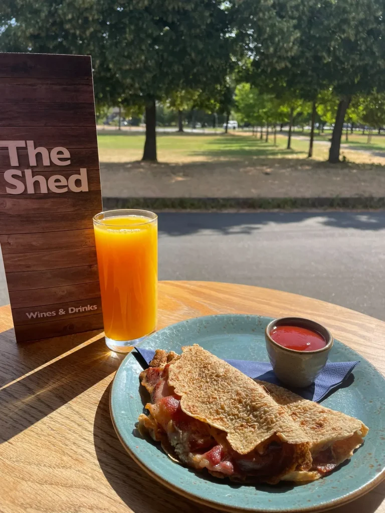 Breakfast oatcake and fresh orange juice in the sunshine outside The Shed