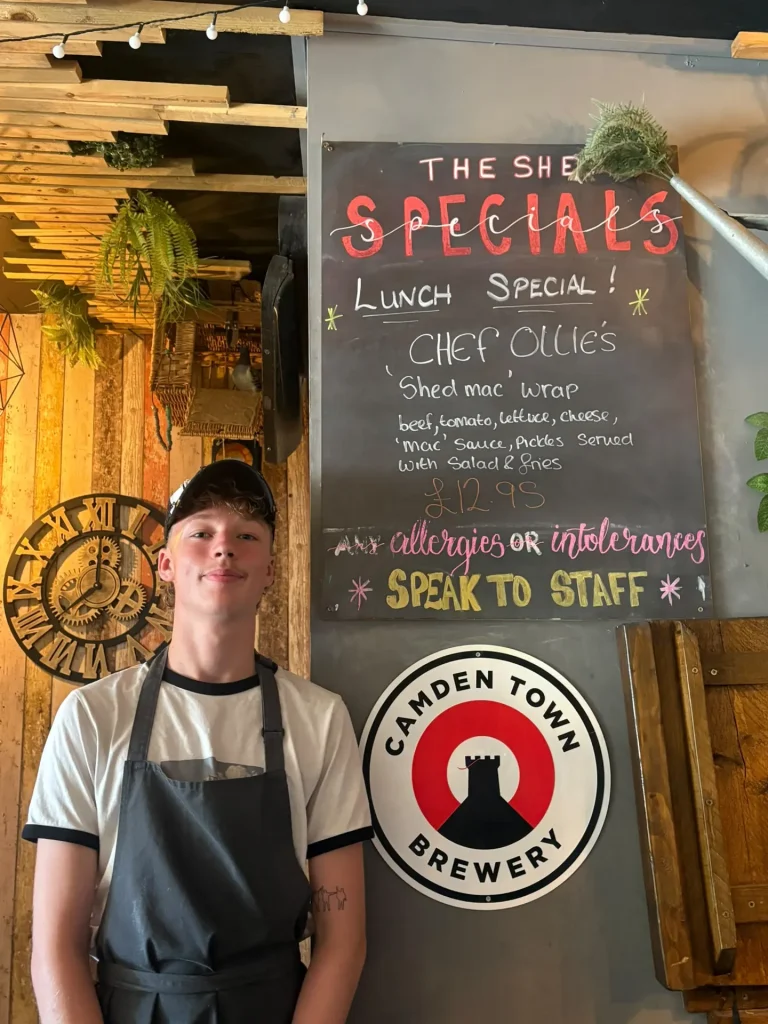The Shed head chef in front of the specials board